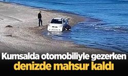 Kumsalda otomobiliyle gezerken, denizde mahsur kaldı