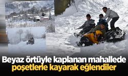 Beyaz örtüyle kaplanan mahallede poşetlerle kayarak eğlendiler
