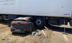 Otomobil, tırın altında metrelerce sürüklendi