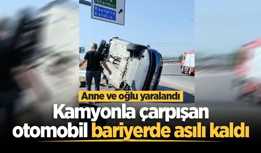 Kamyonla çarpışan otomobil bariyerde asılı kaldı: Anne ve oğlu yaralandı